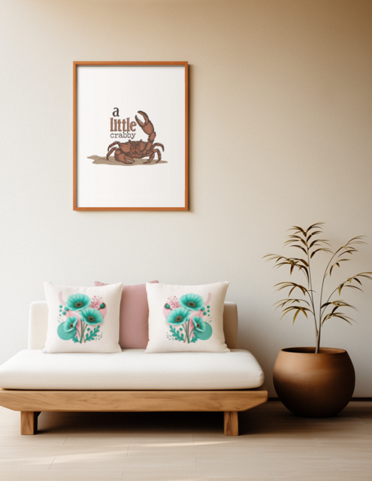 Zwei quadratische Baumwoll Kissen mit modernem Mohnblumen-Design platziert auf einem Sofa im Japandi Stil. Das Motiv zeigt ein Arrangement aus drei großen, strahlend türkisfarbenen Mohnblüten mit dunkel-goldenen Zentren. Die Blüten sind umgeben von türkisen Knospen, zarten rosa Zweigen und auffälligen, teal-grünen Farnblättern. Der cremefarbene Hintergrund ist mit abstrakten rosa und türkisen Kreisen, feinen goldenen Linienbögen und Glitzerpunkten gestaltet.