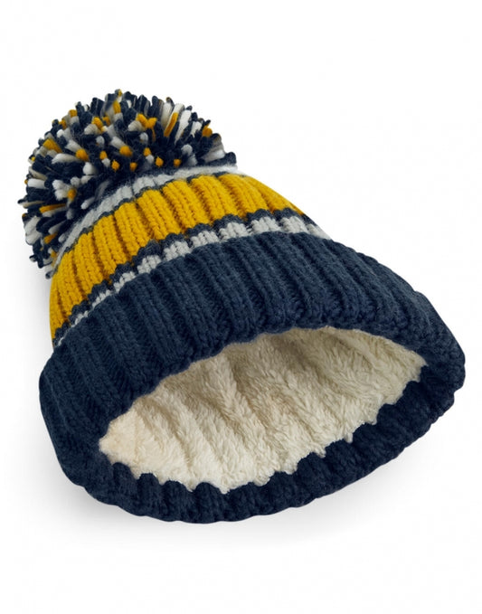 Unisex Strickmütze in dijon blue mit Bommel mit drei unterschiedlichen Farben ( dunkelblau, gelb und weiß) mit breitem Umschlag und strukturiertem Strickmuster.