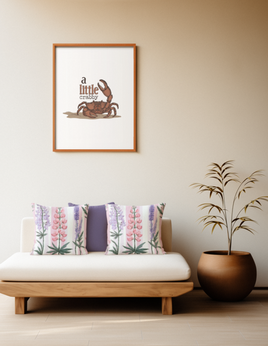Zwei quadratische Baumwoll Kissen mit botanischem Lupinen-Muster platziert auf einem Sofa im Japandi Stil. Das Design zeigt vertikal wachsende, detailreiche Lupinenblüten in Rosa, Hellviolett und Dunkelblau mit sternförmigen grünen Blättern am Stielansatz. Der Hintergrund besteht aus gleichmäßigen, vertikalen Streifen in zartem Rosa und Weiß.