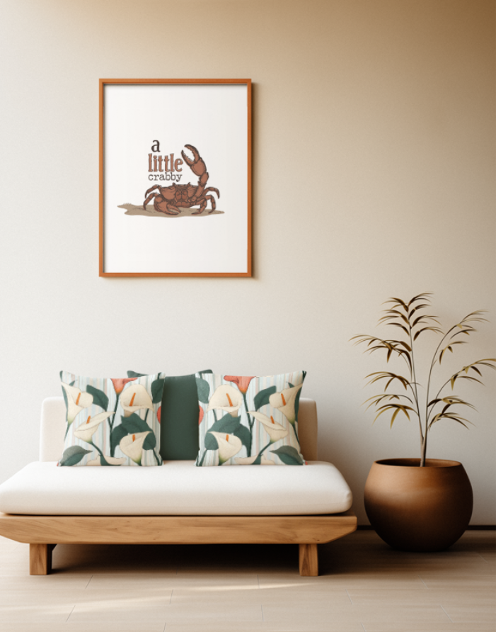 Zwei quadratische Baumwoll Kissen mit Calla-Lilien-Muster platziert auf einem Sofa im Japandi Stil. Das Design zeigt große weiße und eine lachsrote Calla-Blüte mit markanten orangefarbenen Blütenkolben sowie dunkelgrünen Blättern. Der Hintergrund ist mit feinen, vertikalen Streifen in Hellblau, sanftem Rosa und Weiß gestaltet.