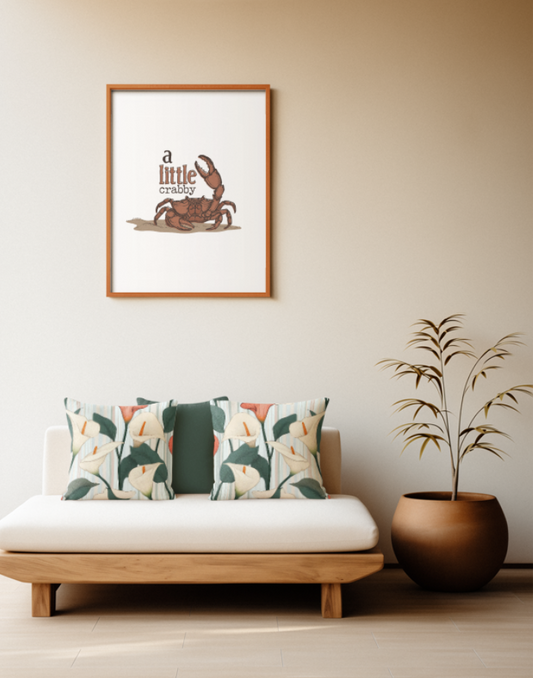 Zwei quadratische Baumwoll Kissen mit Calla-Lilien-Muster platziert auf einem Sofa im Japandi Stil. Das Design zeigt große weiße und eine lachsrote Calla-Blüte mit markanten orangefarbenen Blütenkolben sowie dunkelgrünen Blättern. Der Hintergrund ist mit feinen, vertikalen Streifen in Hellblau, sanftem Rosa und Weiß gestaltet.