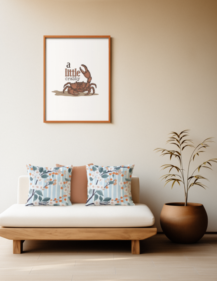 Zwei quadratische Baumwoll Kissen mit Orangenblüten-Muster platziert auf einem Sofa im Japandi Stil. Das Design zeigt dunkle Zweige mit kleinen weißen Orangenblüten, graublauen Blättern und runden, orangefarbenen Früchten. Der Hintergrund besteht aus feinen, vertikalen Streifen in Hellblau und Weiß mit einer leichten Textur.