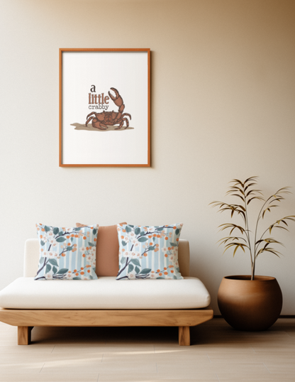 Zwei quadratische Baumwoll Kissen mit Orangenblüten-Muster platziert auf einem Sofa im Japandi Stil. Das Design zeigt dunkle Zweige mit kleinen weißen Orangenblüten, graublauen Blättern und runden, orangefarbenen Früchten. Der Hintergrund besteht aus feinen, vertikalen Streifen in Hellblau und Weiß mit einer leichten Textur.