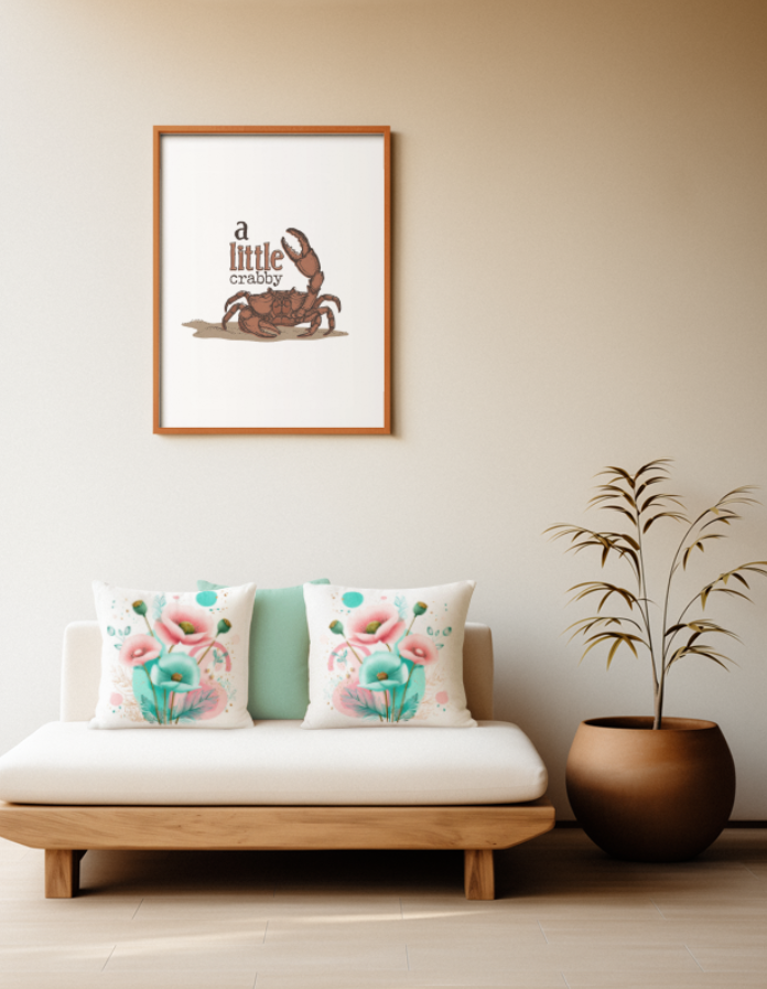 Zwei quadratische Baumwoll Kissen mit modernem Mohnblumen-Muster platziert auf einem Sofa im Japandi Stil. Das Design zeigt ein kunstvolles Arrangement aus rosa und türkisfarbenen Mohnblüten, grünen Kapseln, feinen goldenen Blätter-Linienzeichnungen und abstrakten Kreisen in Türkis und Rosa auf cremefarbenem Grund.