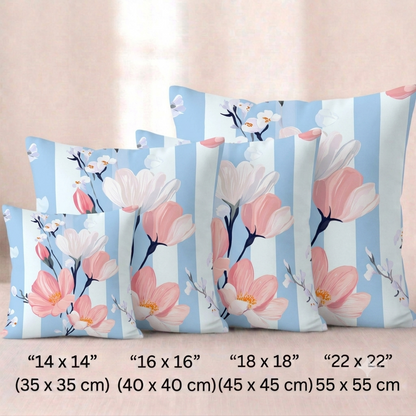 Vier quadratische Baumwoll -Kissenbezüge mit Magnolien-Muster vor einem hellen Hintergrund. Das Design zeigt Zweige mit großen rosa und weißen Magnolienblüten sowie kleine, zarte weiße Blütenknospen. Der Hintergrund besteht aus breiten, vertikalen Streifen in Hellblau mit einer feinen Holz- oder Aquarelltextur und Weiß.