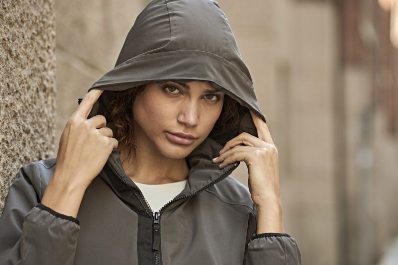 Damen Adventure Jacke in Dark Olive mit glatter Oberfläche und leicht taillierter Passform. Mit Kapuze, hochschließendem Kragen, Frontreißverschluss und seitlichen Eingriff Taschen.