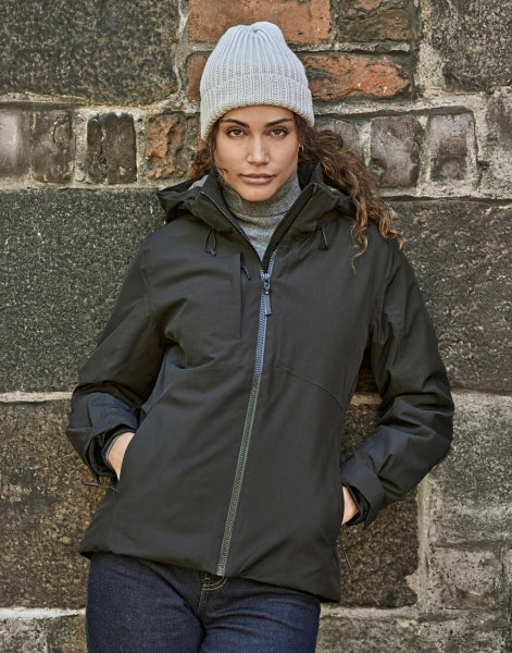 Damen All Weather Winter Jacke mit Kapuze  in  schwarz mit geradem, längerem Schnitt bis über die Hüfte. Schlichtes Design mit hochstehendem Kragen, verdecktem Frontreißverschluss und zwei seitlichen Reißverschlusstaschen.