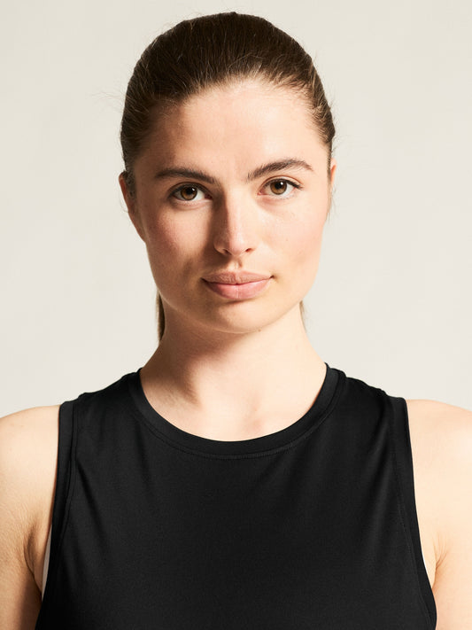 Locker geschnittenes, ärmelloses Sport Top in schwarz mit rundem Halsausschnitt, breiten Schulterpartien, großzügigen Armausschnitten und leicht abgerundetem Saum.