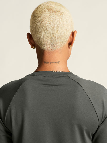 Langärmliges Sportshirt in der Farbe Lava mit rundem Halsausschnitt, Raglanärmeln und locker körpernaher Passform. Der Saum ist leicht abgerundet und hinten etwas länger geschnitten.
