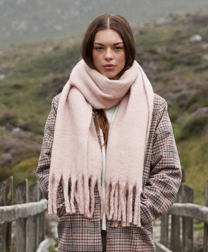 Oversized Schal für Damen in Blush Pink aus weichem, voluminösem Material mit leicht strukturierter Oberfläche, breiter Form und langen, dicht gesetzten Fransen an beiden Enden.
