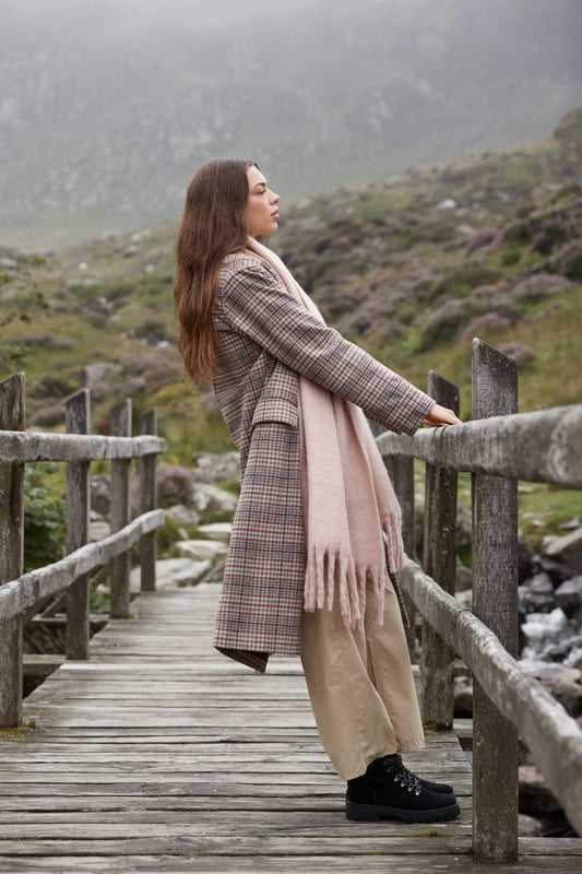 Oversized Schal für Damen in Blush Pink aus weichem, voluminösem Material mit leicht strukturierter Oberfläche, breiter Form und langen, dicht gesetzten Fransen an beiden Enden.
