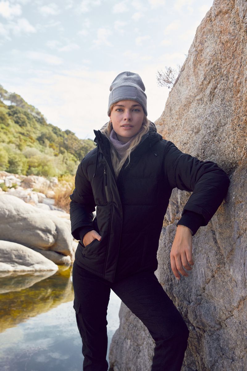 Damen Colorado Winterjacke in Schwarz mit horizontaler Steppung und hüftlangem Schnitt. Die Jacke hat eine Kapuze, einen durchgehenden Frontreißverschluss und zwei seitliche Eingriff Taschen.