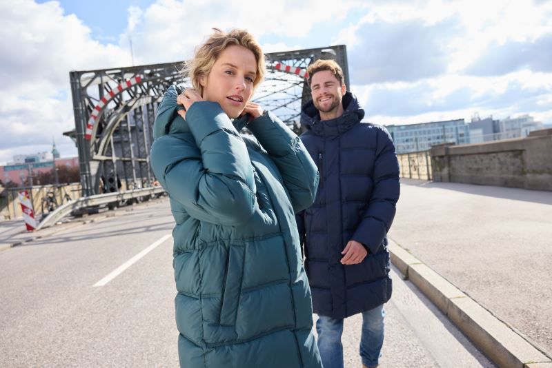 Damen Pufferjacke in Smokey Green mit gleichmäßiger horizontaler Steppung und voluminöser Wattierung. Knielanger Schnitt mit Kapuze, hochschließendem Kragen, durchgehendem Frontreißverschluss und seitlichen Eingriff Taschen.