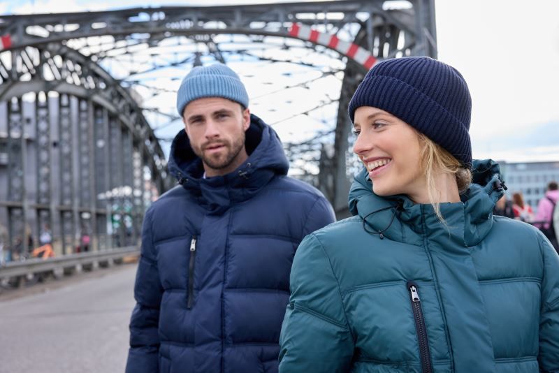 Damen Pufferjacke in Smokey Green mit gleichmäßiger horizontaler Steppung und voluminöser Wattierung. Knielanger Schnitt mit Kapuze, hochschließendem Kragen, durchgehendem Frontreißverschluss und seitlichen Eingriff Taschen.