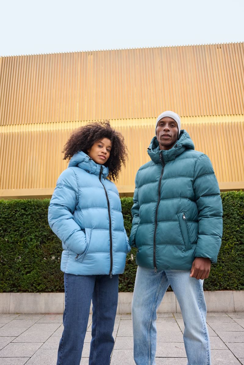 Damen Pufferjacke in Milky Blue mit gleichmäßiger horizontaler Steppung und voluminöser Wattierung. Hüftlanger Schnitt mit Kapuze, hochschließendem Kragen, durchgehendem Frontreißverschluss und seitlichen Eingriff Taschen.
