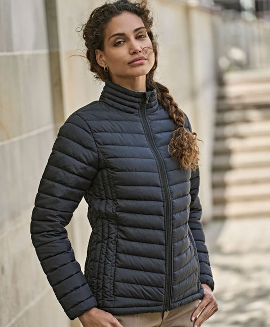 Damen Zeppelin Jacke in Schwarz mit schmaler, horizontaler Steppung über Vorderseite, Rücken und Ärmel. Körpernah geschnitten mit hohem Stehkragen, durchgehendem Reißverschluss und dezent integrierten Seitentaschen.