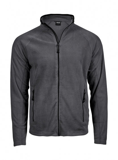 Dunkelgraue Fleecejacke mit körpernahem, geradem Schnitt und leicht strukturierter Oberfläche. Die hüftlange Jacke hat einen aufgestellten Kragen, schmale lange Ärmel und zwei seitliche Reißverschlusstaschen. Dezente dunkle Einfassungen an Kragen, Reißverschluss und Taschen unterstreichen das schlichte, sportliche Design.
