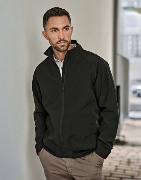 Schwarze Herren-Clubjacke in sportlich-eleganter Optik mit glatter Oberfläche, leicht tailliertem Schnitt, hochstellbarem Kragen, verdeckten Seitentaschen und schwarzem Frontreißverschluss.