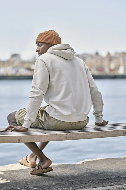 Herren Heavy Hoodie in Cement mit lässiger Passform und cleanem, einfarbigem Design. Mit großer Kapuze samt Kordelzug, langen Ärmeln, breiten Rippbündchen und klassischer Kängurutasche auf der Vorderseite.