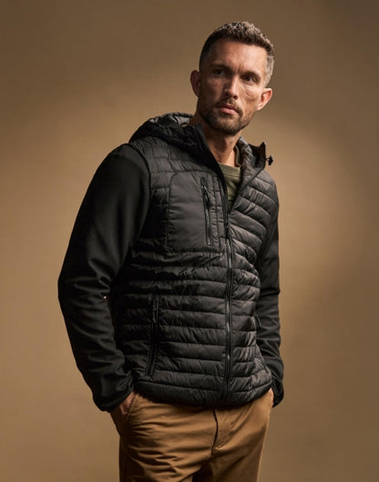 Herren Hooded Crossover Jacke in schwarz mit horizontal gesteppter Vorderseite und glatten Stretch-Ärmeln. Körpernah geschnitten mit Kapuze, hohem Kragen und durchgehendem Frontreißverschluss.