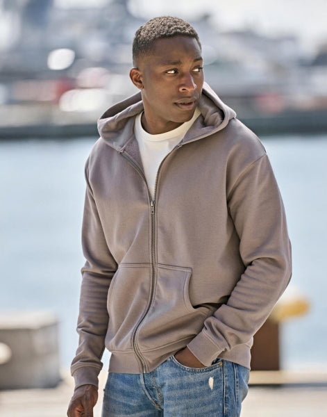 Herren Kapuzenpullover mit Reißverschluss in Cement mit lässiger Passform und cleanem, einfarbigem Design. Mit großer Kapuze samt Kordelzug, langen Ärmeln, breiten Rippbündchen und klassischer Kängurutasche auf der Vorderseite.
