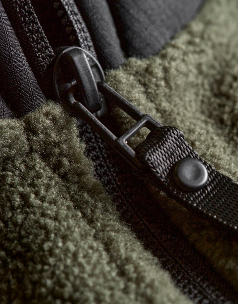 Mountain Fleece Bodywarmer in Deep Green/Black mit schwarzem Reißverschluss und dunklen Kontrastbesätzen an Brust und Schultern. Die hüftlange Weste ist körpernah geschnitten, hat einen hohen Kragen und seitliche Reißverschlusstaschen.