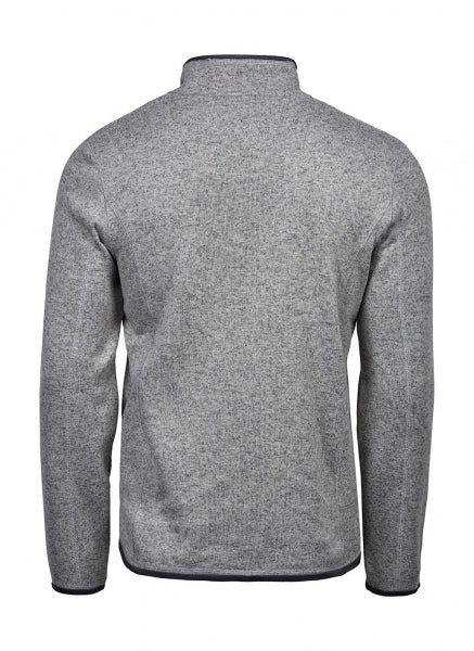 Graue Outdoor Fleece Jacke in geradem, körpernahem Schnitt. Die hüftlange Fleecejacke hat einen hohen Stehkragen, lange Ärmel und zwei seitliche Reißverschlusstaschen. Das schlichte Design wird durch dezente schwarze Details an Reißverschlüssen und Abschlüssen ergänzt.