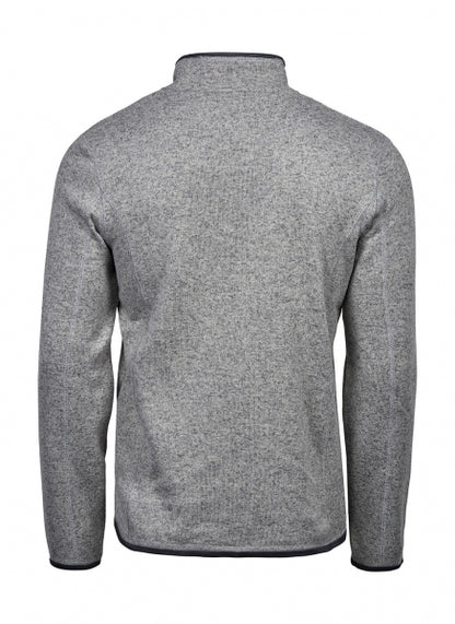Graue Outdoor Fleece Jacke in geradem, körpernahem Schnitt. Die hüftlange Fleecejacke hat einen hohen Stehkragen, lange Ärmel und zwei seitliche Reißverschlusstaschen. Das schlichte Design wird durch dezente schwarze Details an Reißverschlüssen und Abschlüssen ergänzt.