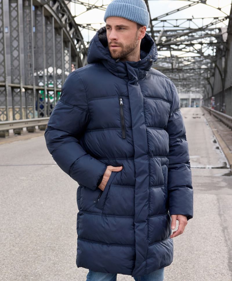 Herren Puffermantel in Dunkelblau mit gleichmäßiger horizontaler Steppung und voluminöser Wattierung. Knielanger Schnitt mit Kapuze, hochschließendem Kragen, durchgehendem Frontreißverschluss und seitlichen Eingriff Taschen.