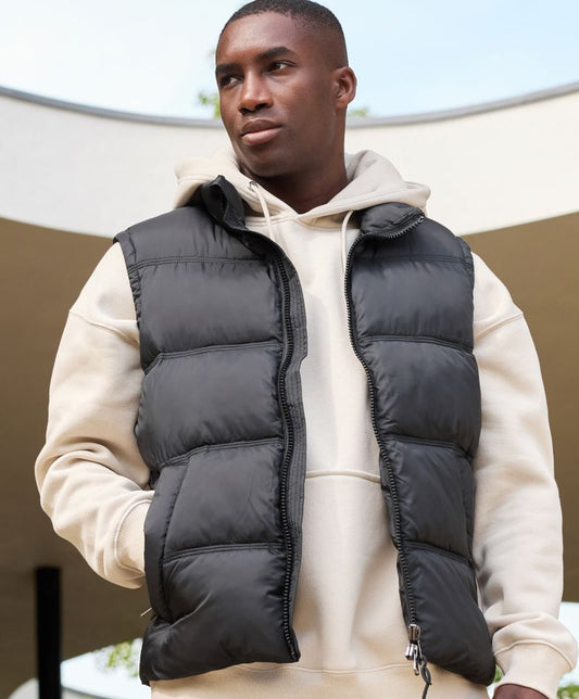 Herren Puffer Weste in schwarz mit gleichmäßiger horizontaler Steppung und voluminöser Wattierung. Hüftlanger Schnitt und hochschließendem Kragen, durchgehendem Frontreißverschluss und seitlichen Eingriff Taschen.