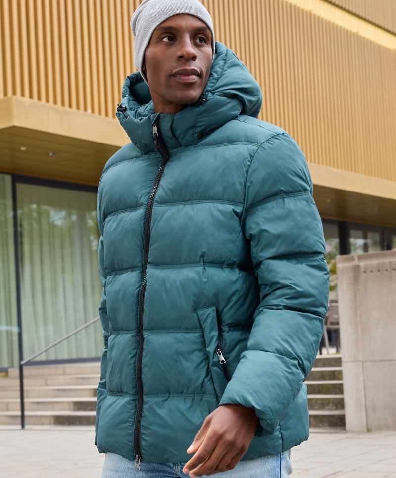 Damen Pufferjacke in Smoky Green mit gleichmäßiger horizontaler Steppung und voluminöser Wattierung. Hüftlanger Schnitt mit Kapuze, hochschließendem Kragen, durchgehendem Frontreißverschluss und seitlichen Eingriff Taschen.