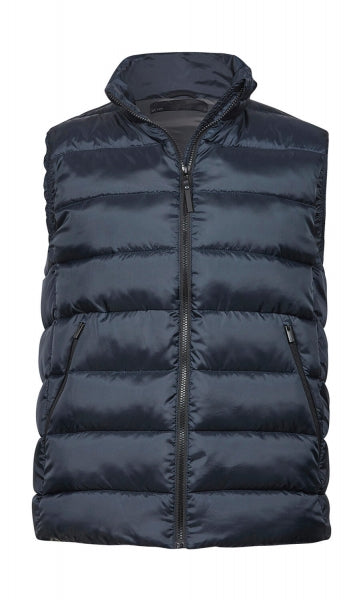 Eine  tief navy blaue Steppweste ist mit schmaler, horizontaler Steppung und hohem Stehkragen. Die leicht wattierte Weste reicht bis zur Hüfte und ist körpernah geschnitten. Zwei seitliche Taschen sind dezent in das Design integriert.